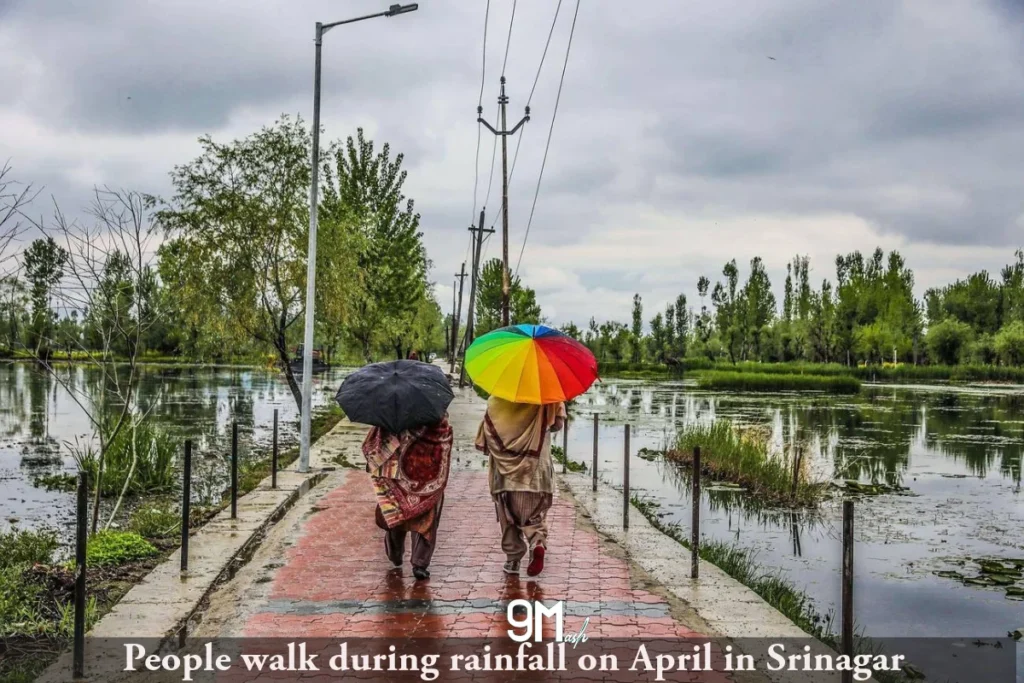 People walk during rainfall in April in Srinagar